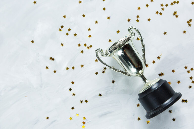 Golden,Trophy,And,Stars,Confetti,On,Gray,Cement,Background.,Sport