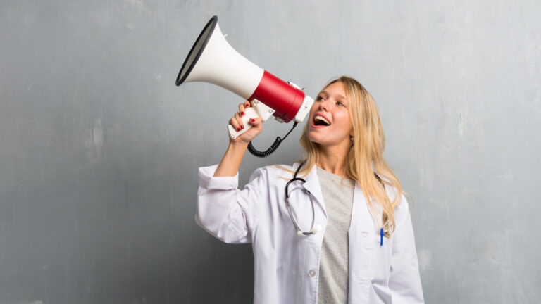 Young doctor woman holding a megaphone