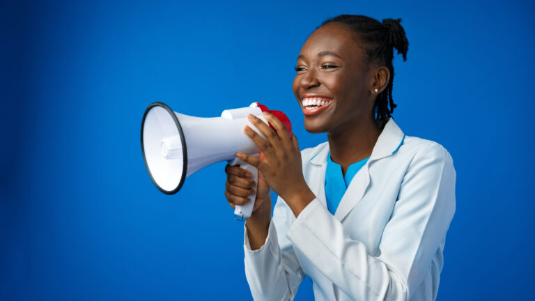 Afro american female doctor in white medical gown scream in megaphone in studio