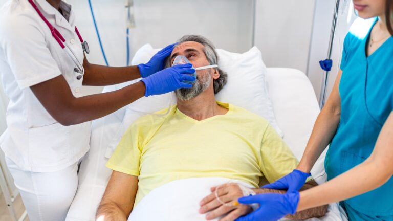 man with oxygen in hospital bed