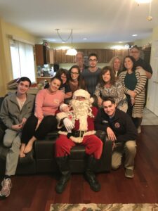 Large family at Christmas time posing with Santa Claus.