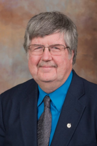 Portrait of Steven Sittig, man with glasses, pepper hair in a tie and suit.